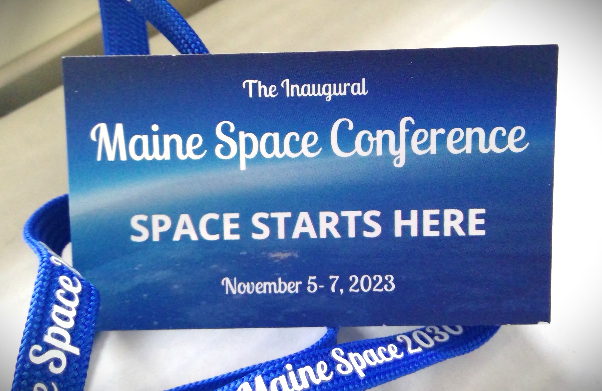 Blue business card with text: The Inaugural Maine Space Conference, Space Starts Here, November 5-7, 2023.